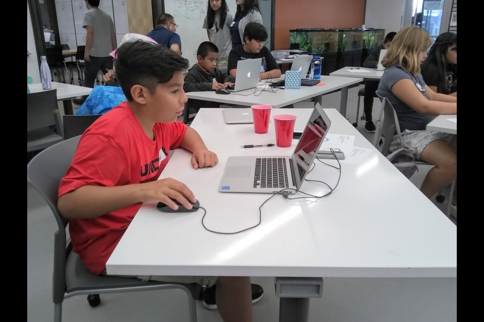 Allan Bustos learning Scratch, a kids' programming language, at Coding Camp. 